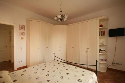 a bedroom with a bed and a tv in it at Azzurra ideale per famiglie in Donoratico