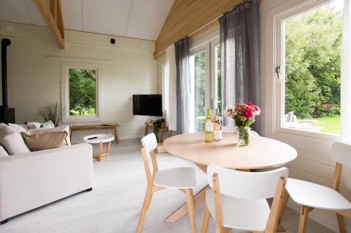 uma sala de estar com uma mesa e cadeiras e um sofá em Chalet met loft - vakantiepark de Schreiershoek em Dokkum