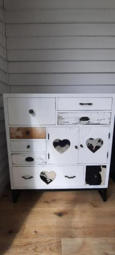 a white dresser with many drawers on it at La vache au lit in Damme