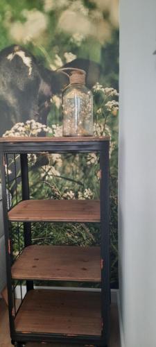 a wooden shelf with a glass jar on top of it at La vache au lit in Damme