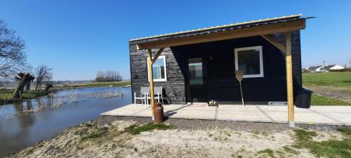 a small house on a dock next to a river at La vache au lit in Damme