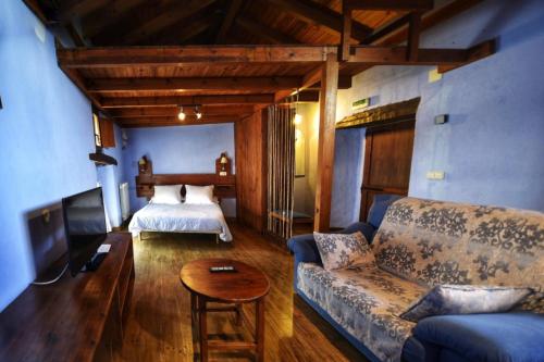 ein Wohnzimmer mit einem Sofa und einem Bett in der Unterkunft palacio de Orisoain in Orísoain