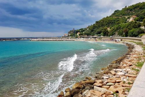 a beach with a rocky shore and the ocean at HOTEL DEL GOLFO in Finale Ligure