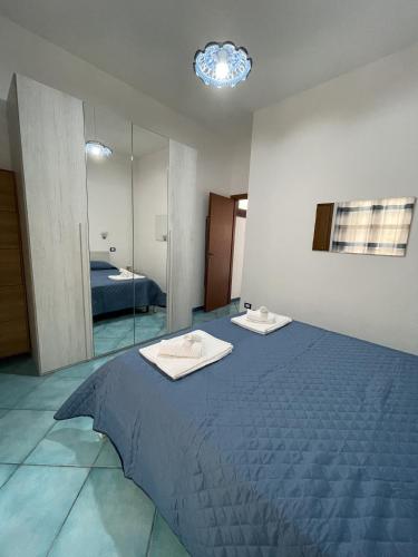 - une chambre avec un grand lit et un miroir dans l'établissement Le Casette Sul Lungomare, à Sciacca