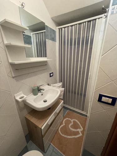La petite salle de bains est pourvue d'un lavabo et d'une douche. dans l'établissement Le Casette Sul Lungomare, à Sciacca