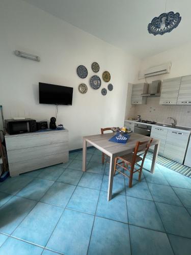 a kitchen with a table and chairs and a television at Le Casette Sul Lungomare in Sciacca