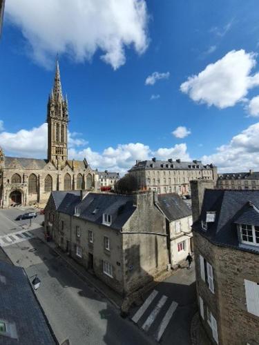 un ancien bâtiment avec une tour de l'horloge et une église dans l'établissement studio centre ville 3ème étage sans ascenceur, à Saint-Pol-de-Léon