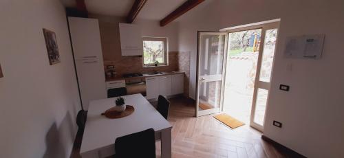 una cocina con una mesa blanca y una puerta a un patio en Villa Carol, en Santa Maria di Castellabate