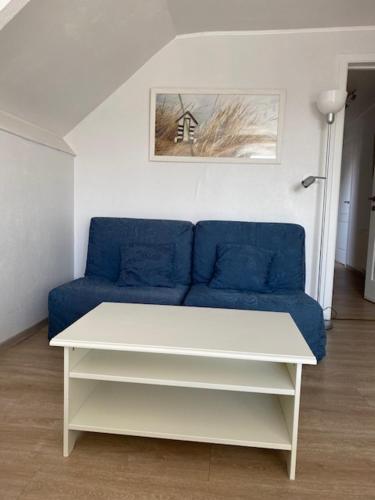 - un salon avec un canapé bleu et une table dans l'établissement Logies Villa Maxim, à Coxyde