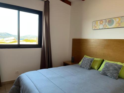 a bedroom with a bed with a large window at Residences La Tonnara in Bonifacio