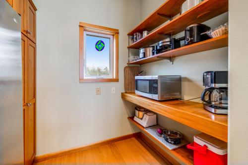 a small kitchen with a microwave and a window at Escape to the Cape in Tillamook