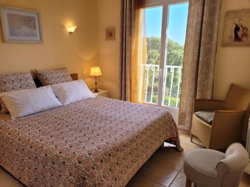 une chambre avec un lit, une fenêtre et une chaise dans l'établissement Villa à Pinarello-2mn à pied de la plage-vue mer, à Pinarellu