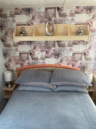 a bedroom with a bed and a wall with flowers at L&g caravan hire 8 BERTH SEALANDS FAMILYS ONLY AND THE LEAD PERSON MUST BE OVER 30 in Ingoldmells