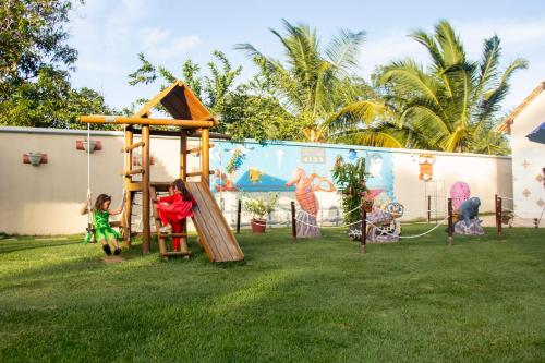 dwójka dzieci bawiących się na placu zabaw w ogrodzie w obiekcie Pousada Polymar w mieście Maragogi