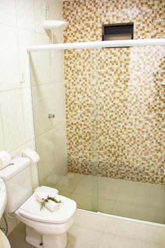 a bathroom with a toilet and a shower at Pousada Polymar in Maragogi