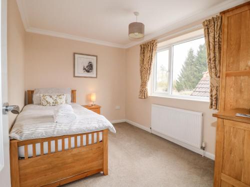 a bedroom with a bed and a window at Aditum Cottage in Market Rasen