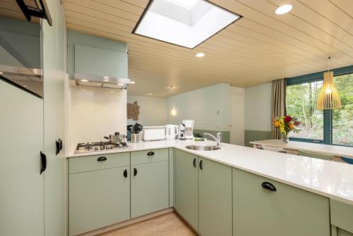 a kitchen with white cabinets and a skylight at Center Parcs Huttenheugte Drenthe-Overijssel in Dalen