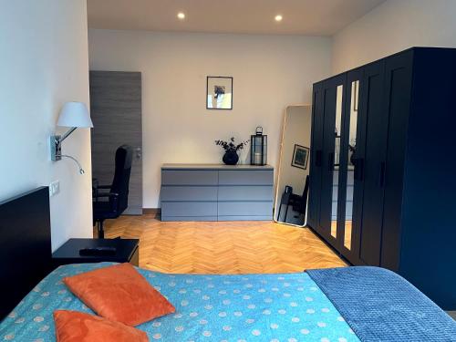 um quarto com uma cama azul e uma cómoda azul em The Lighthouse - Central Apartment Aosta - cir 0234 em Aosta