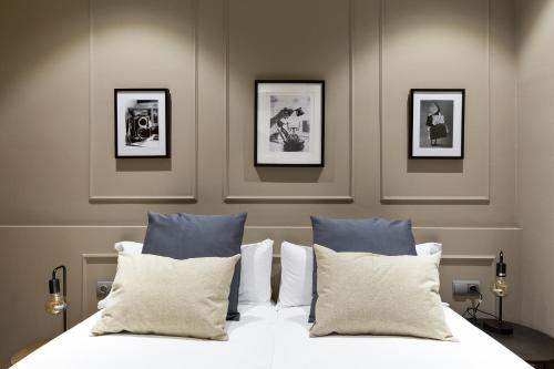 a bedroom with a bed with four pictures on the wall at Sagrada266 by chicStays in Barcelona