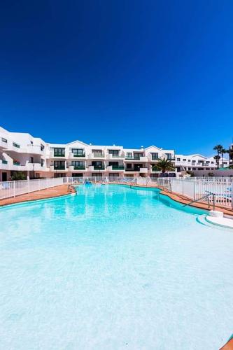 a large swimming pool in front of a building at App Tahiche, Encanto Canario in Costa Teguise