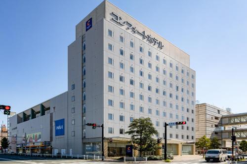un edificio bianco con un cartello sul lato di Comfort Hotel Toyokawa a Toyokawa