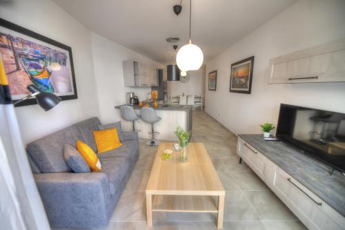 a living room with a couch and a table and a television at Bright and beautifully furnished apartment close to seafront BFRA1-2 in Il-Gżira