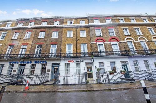 a large brick building on a city street at OYO Townhouse 30 Sussex Hotel, London Paddington in London