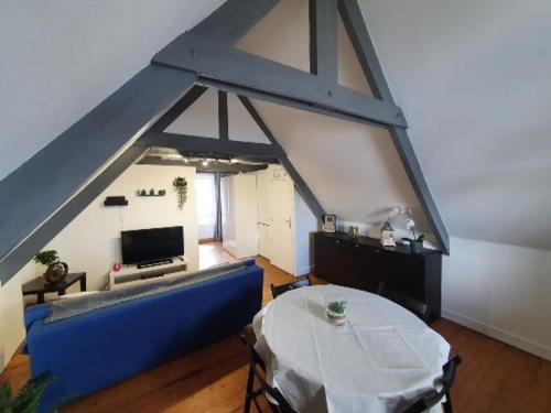 a living room with a blue couch and a table at studio centre ville 3ème étage sans ascenceur in Saint-Pol-de-Léon