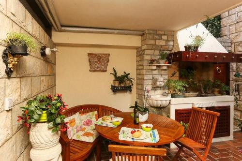 a patio with a wooden table and chairs and a kitchen at Flower House - Lapad in Dubrovnik