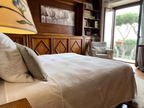 a bedroom with a bed and a chair and a window at “Casa Amélie” in Grottaferrata