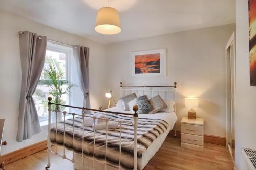 a bedroom with a bed and a window at Slipway cottage 21 Picton road in Milford Haven