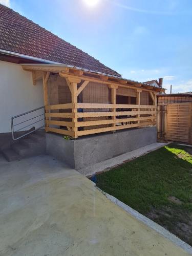 una casa con una valla de madera y un patio en Kakasdombi Apartman en Balatonszabadi