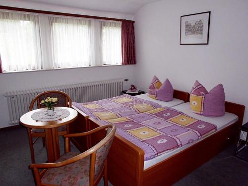 ein Schlafzimmer mit einem Bett mit einem Tisch und einem Stuhl in der Unterkunft Haus Werrablick in Hannoversch Münden