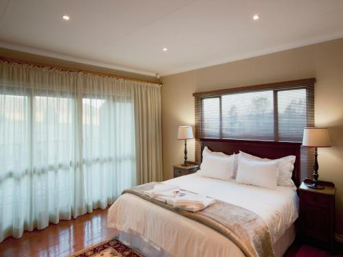 a bedroom with a bed and a large window at Whispering Waters in Fort Nottingham