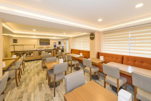 イスタンブールにあるFloransa City Hotelのテーブルと椅子のあるレストラン、キッチンが備わります。