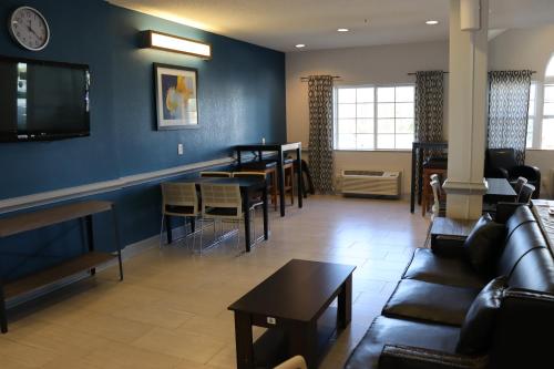 a living room with a couch and a dining room at Microtel Inn & Suites by Wyndham Columbus Near Fort Moore in Columbus
