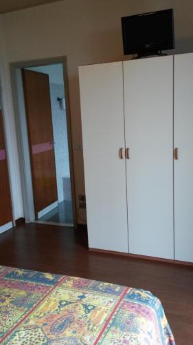 a bedroom with a bed and white cabinets and a mirror at Hotel Giardino in Sirmione
