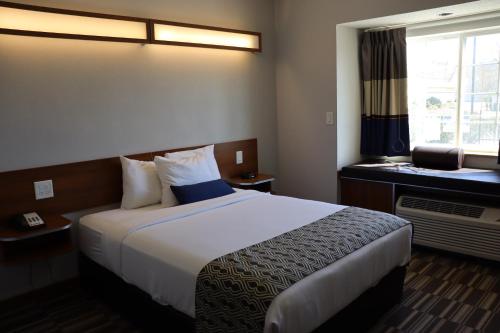 a hotel room with a large bed and a window at Microtel Inn & Suites by Wyndham Columbus Near Fort Moore in Columbus