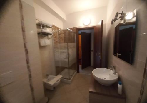La salle de bains est pourvue d'un lavabo, d'une douche et de toilettes. dans l'établissement Hotel San Marino, à Laglio