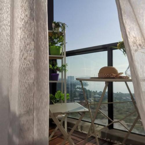 a room with a table and a window with plants at R&F Mall,Country Style Seaview 2 bedrooms in Johor Bahru