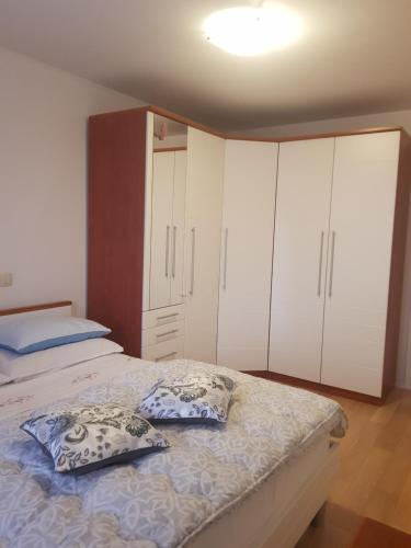 1 dormitorio con 1 cama con armarios y almohadas blancos en Solila apartment en Dubrovnik