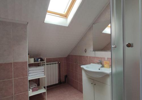 ein Badezimmer mit einem Waschbecken und einem Dachfenster in der Unterkunft House Katja in Jezerce