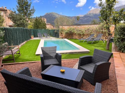 a backyard with a pool and chairs and a table at Cal Tio Lluc in Sóller