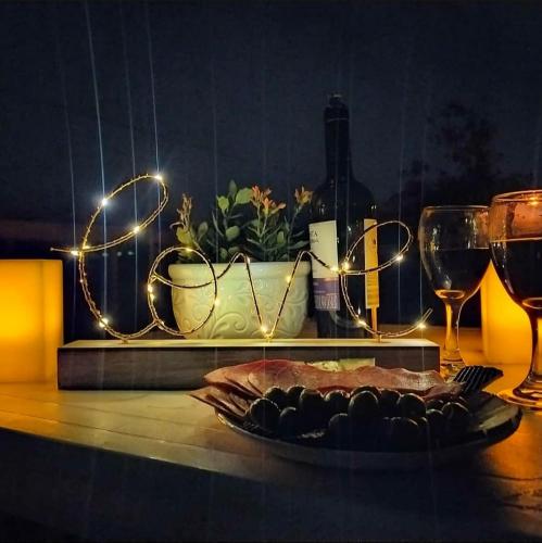 a table with a plate of food and wine glasses at Guané Glamping Ecolodge Jacuzzi Privado Oriente Antioqueño in Guarne