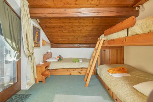 a bedroom with two bunk beds and a ladder at Mansarda alla Pineta in Giustino