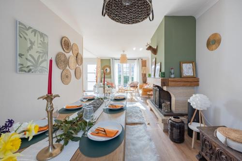 un salon avec une table et une cheminée dans l'établissement Ellisa, à Ver-sur-Mer