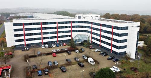 an office building with cars parked in a parking lot at Sapphire House Apartments in Telford