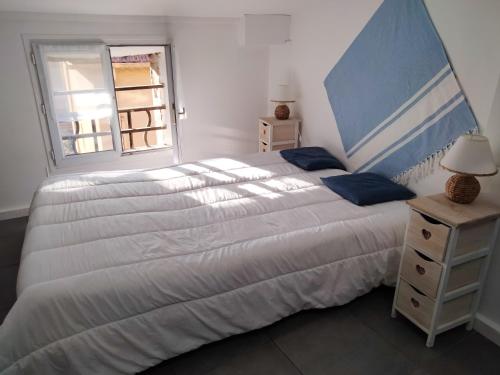 a bedroom with a large white bed and a window at Studio charmant avec vue sur la mer a Cannes 20 m&sup2; terrasse in Cannes