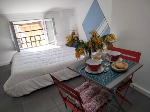 a room with a bed and a table and chairs at Studio charmant avec vue sur la mer a Cannes 20 m&sup2; terrasse in Cannes