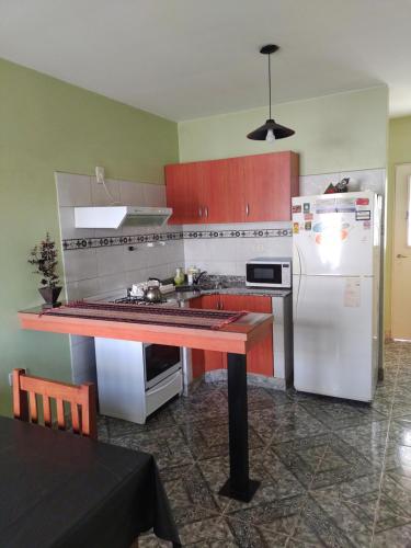 uma cozinha com uma mesa e um frigorífico branco em Ivon em Neuquén